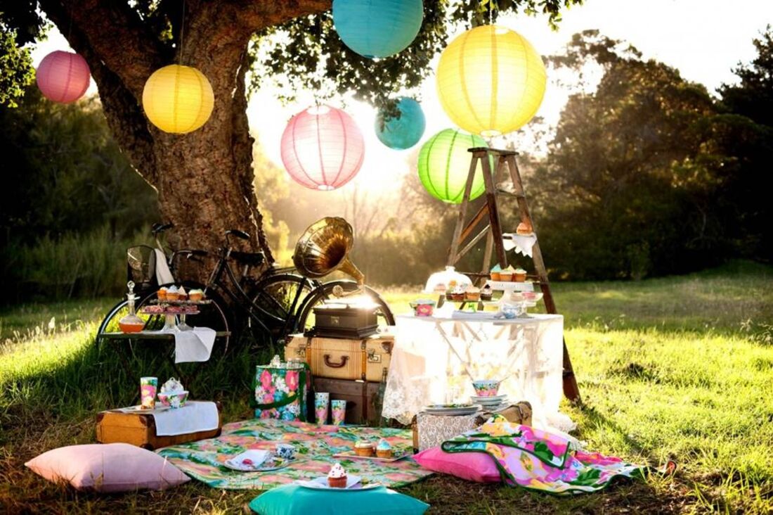 A warm Garden of Eden picnic scene — lanterns glowing at golden hour, the abundance and human connection at the heart of Eden Ascent